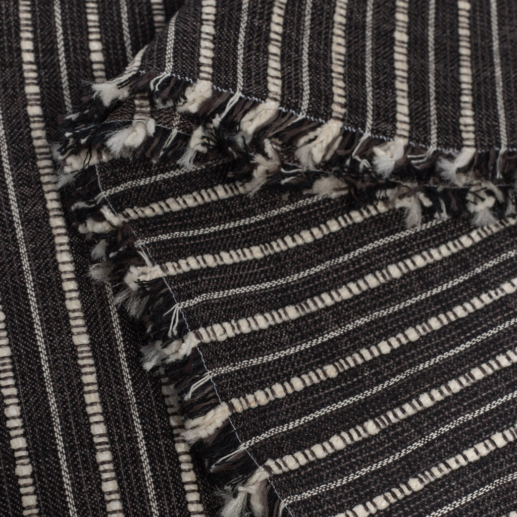 Misto Stripe Charcoal, a faded black and cream striped Crypton home performance fabric : selvage edge view
