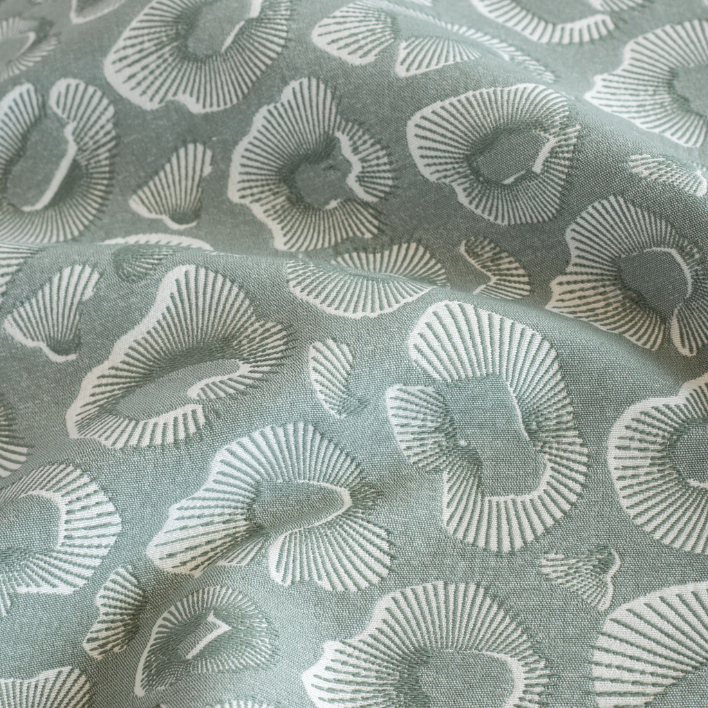 a blue green and white abstract ocean motif pattern upholstery fabric