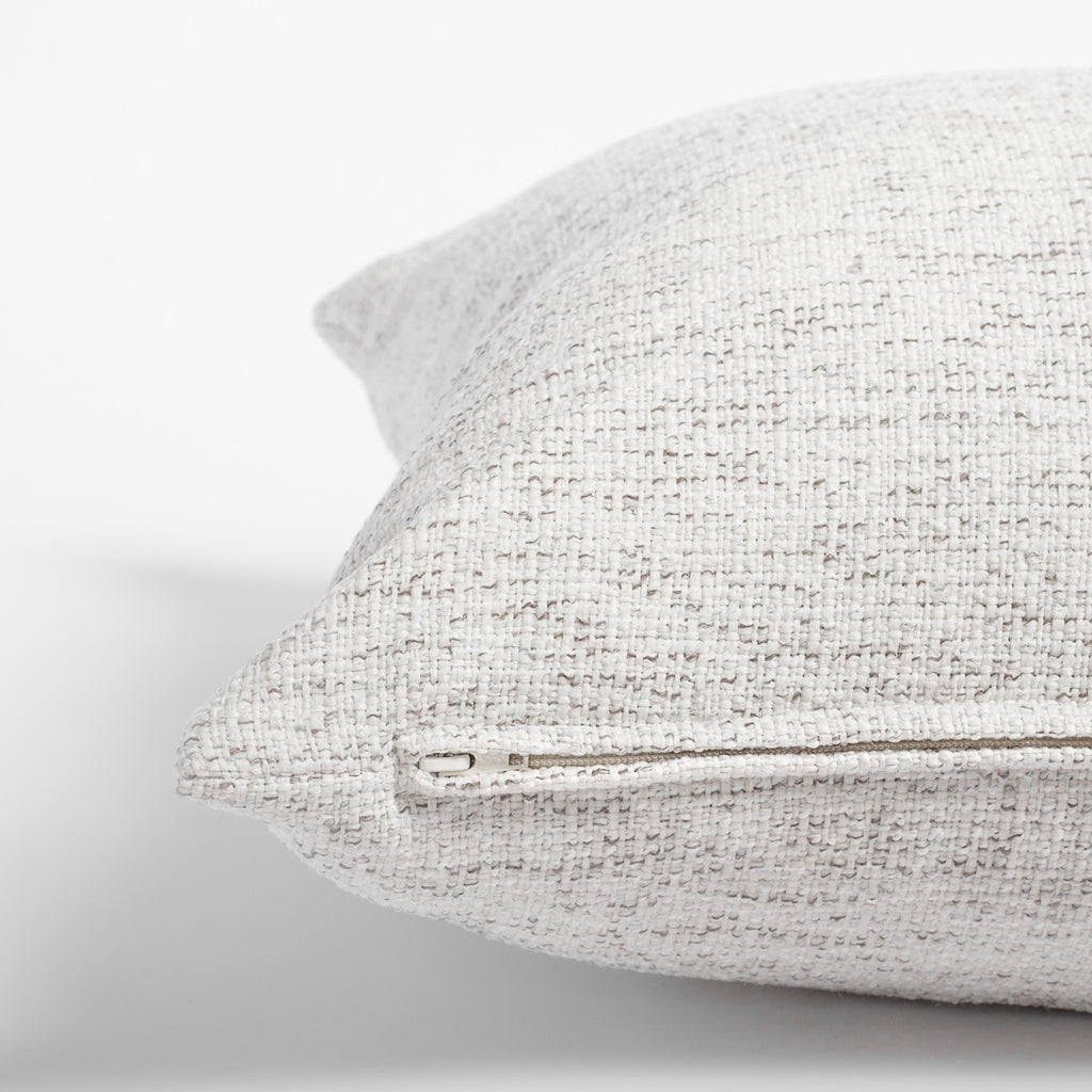 Preston Birch, a heathered cream and light grey indoor outdoor pillow: zipper detail