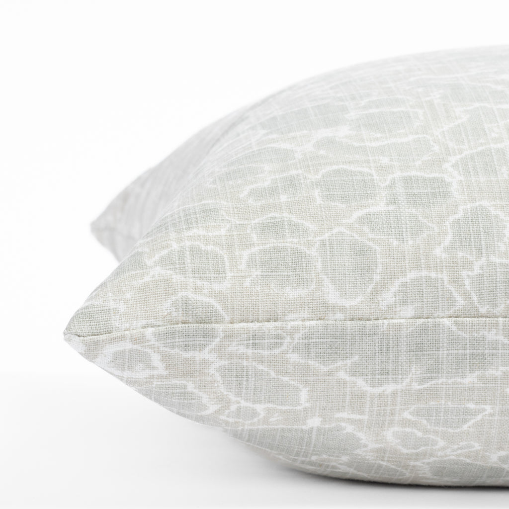 a white and seafoam green dabbled calm ocean surface print throw pillow : close up side view