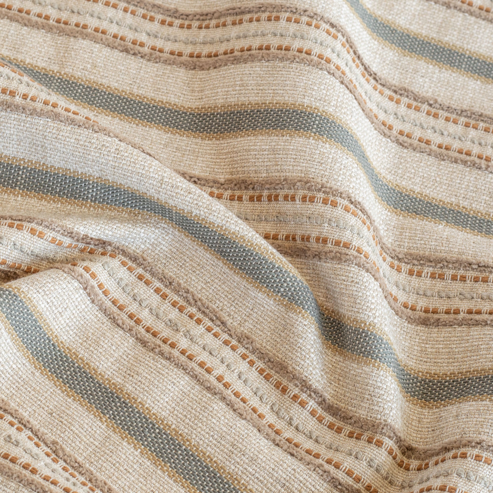 a striped upholstery fabric in beige, brown and grey earth tones