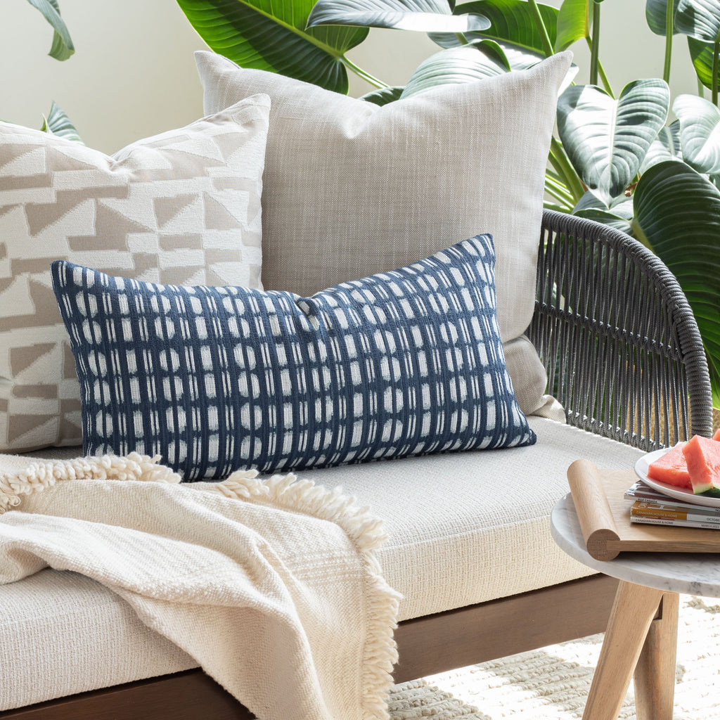 Indoor Outdoor decor vignette: Ryder Swell beige pillow with neutral and blue global pattern pillows from Tonic Living