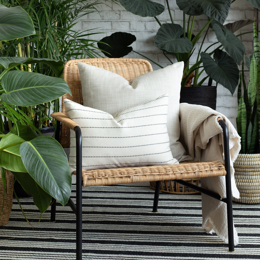 Indoor Outdoor decor vignette: Ryder Swell beige pillow with Fontana cream and black stripe lumbar pillow 