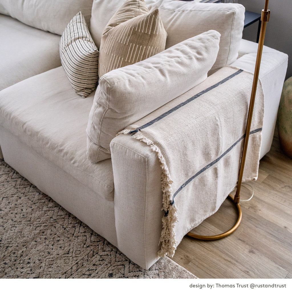Cream sofa with neutral pillows and cream throw blanket