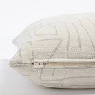 a cream and grey abstract line patterned pillow : zipper detail