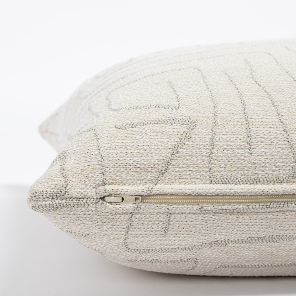 a cream and grey abstract line patterned pillow : zipper detail