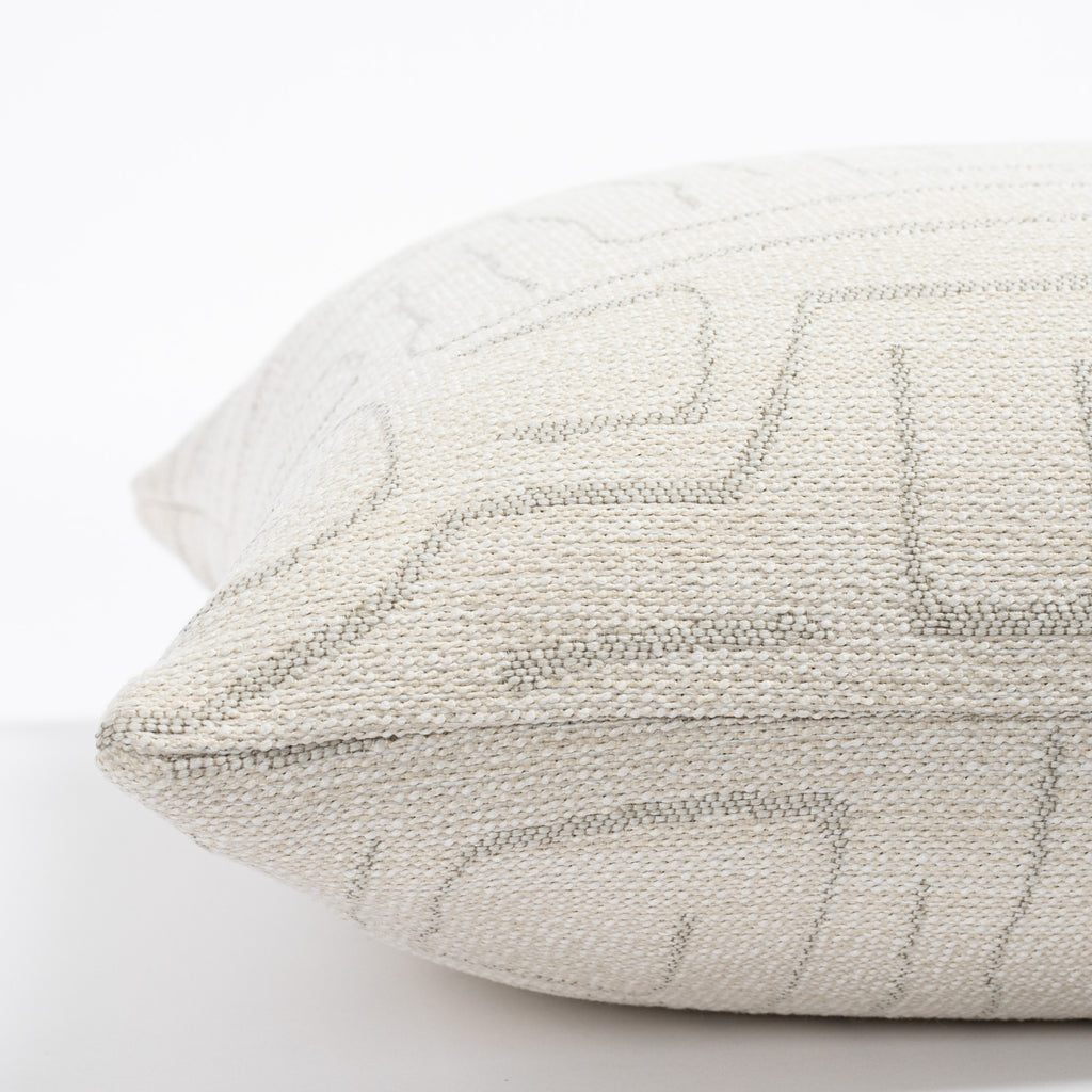 a cream and grey abstract line patterned pillow : side view
